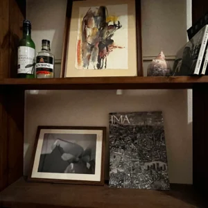 わたしの部屋に飾っているモノクロの芸術写真。濃い茶色の木目フレームに白マットと V カット仕上げで額装し、写真雑誌 IMA や絵画作品と並べて棚にディスプレイしている実例